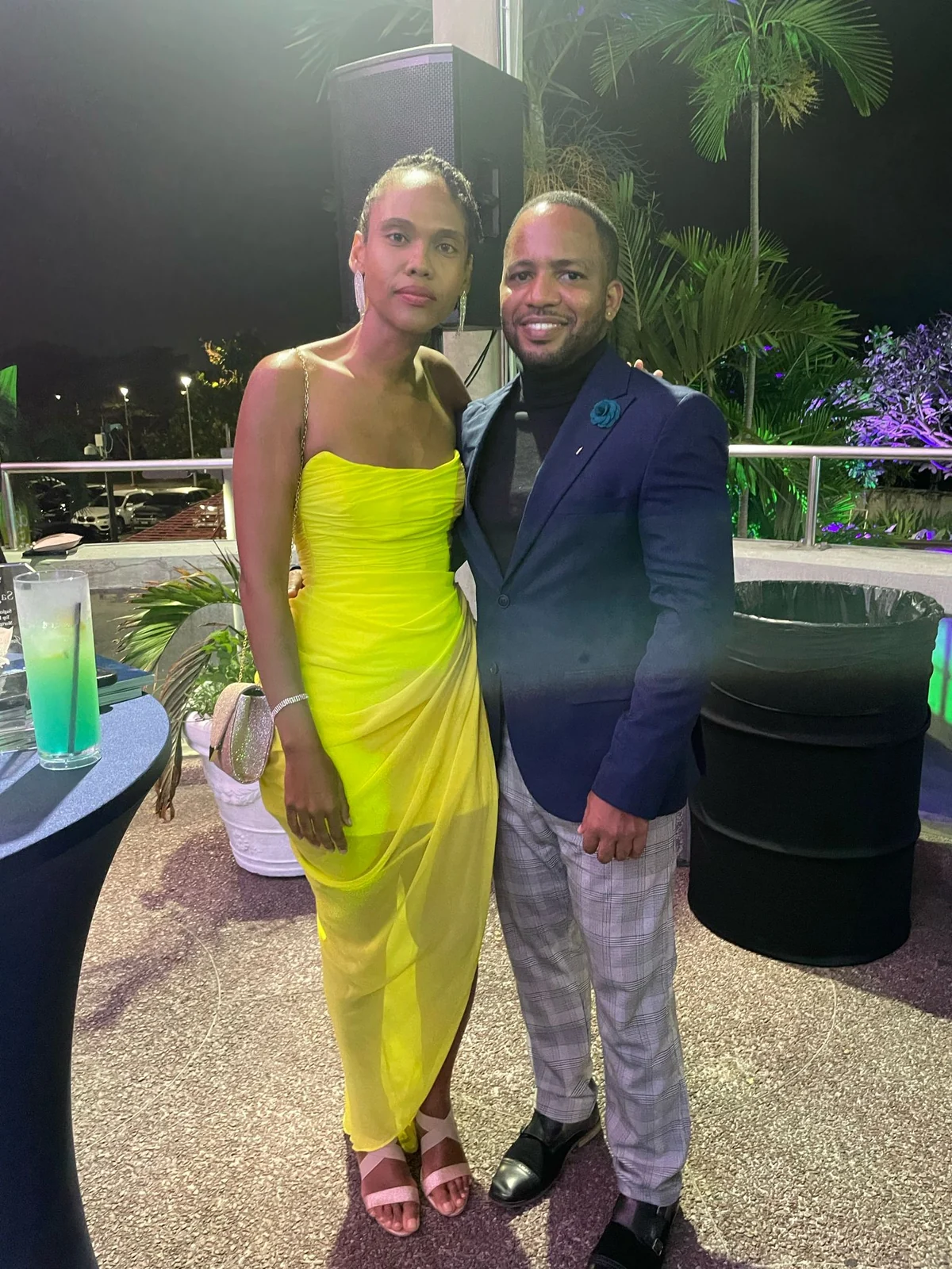 Jamar and a woman in a yellow dress posing outdoors
