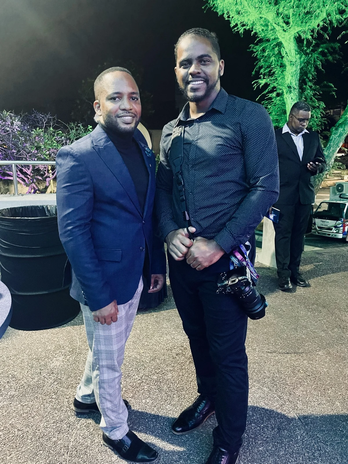 Jamar beside a photographer at an evening gathering