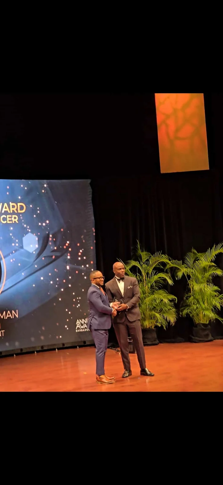 An award presentation and handshake on stage