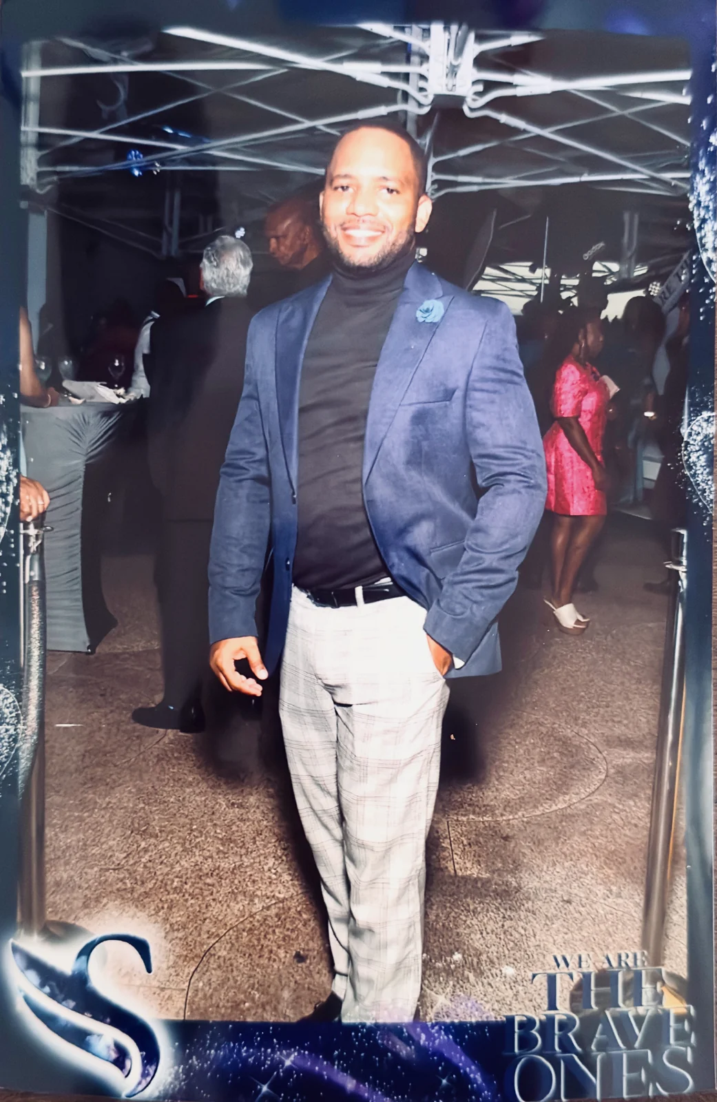 Jamar posing in a blue jacket at an event photo frame