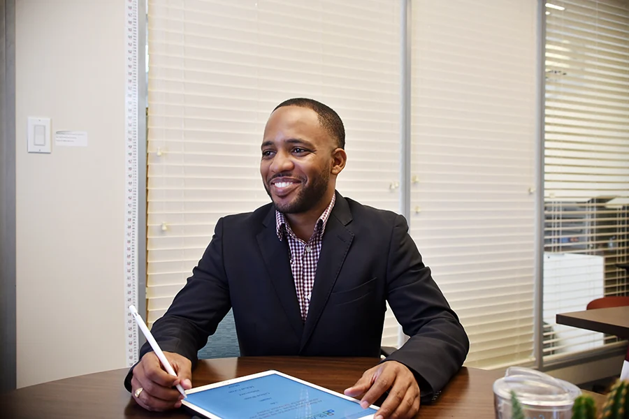 Jamar Blackman at his desk with a notebook, ready for a conversation