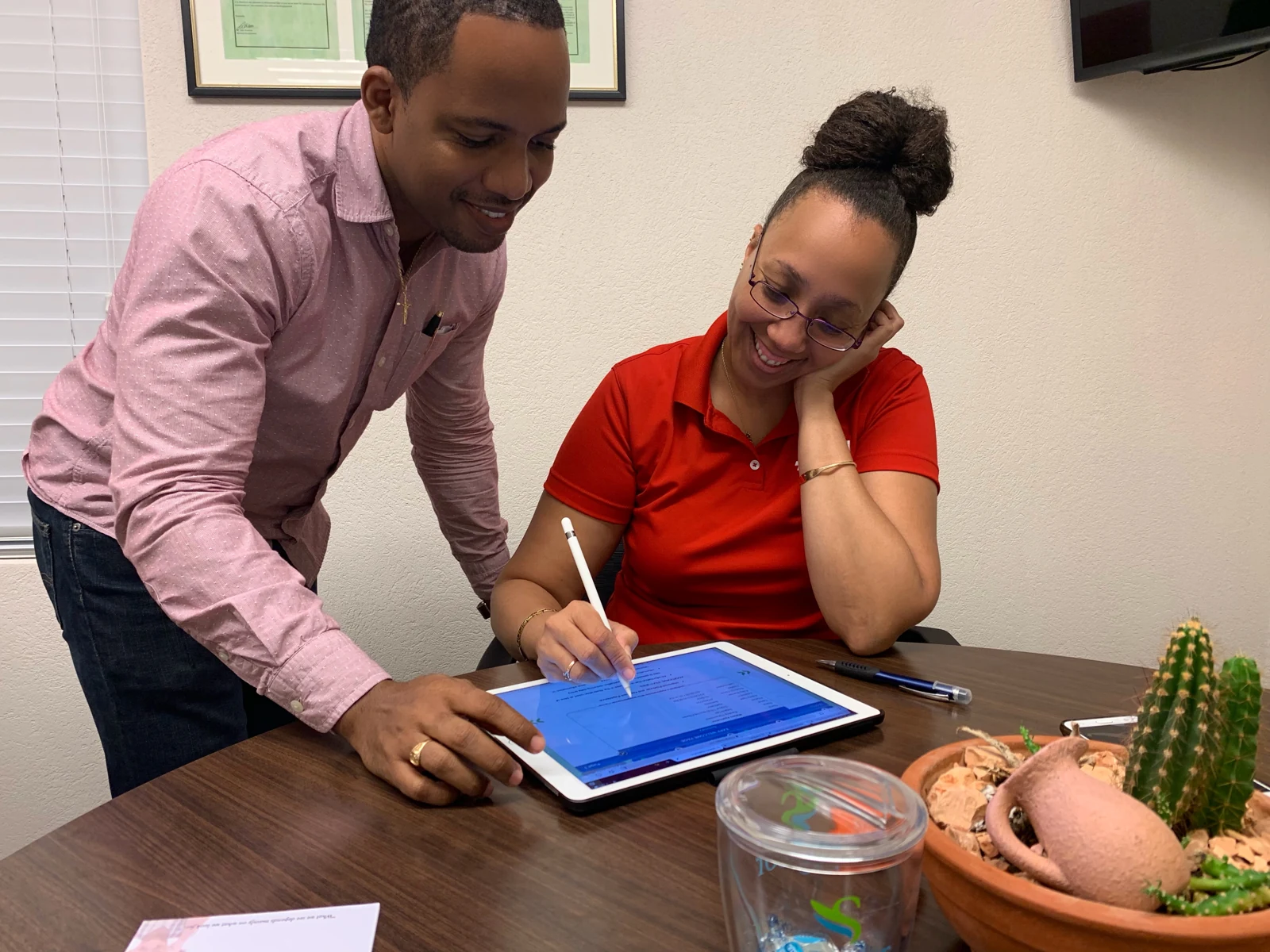 Jamar Blackman helping a client review information on a tablet